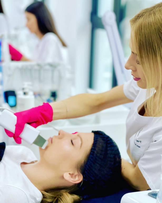 Student performing hydradermabrasion and microneedling mesotherapy during hands-on training.