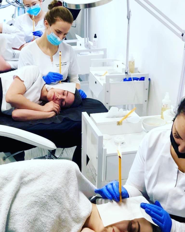 Hands-on ear candling training with auricular massage and treatment preparation.