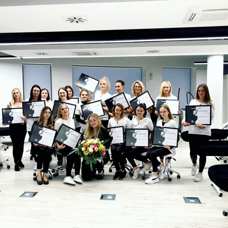 Beauty Expert School graduates celebrating their achievement with professional certificates.