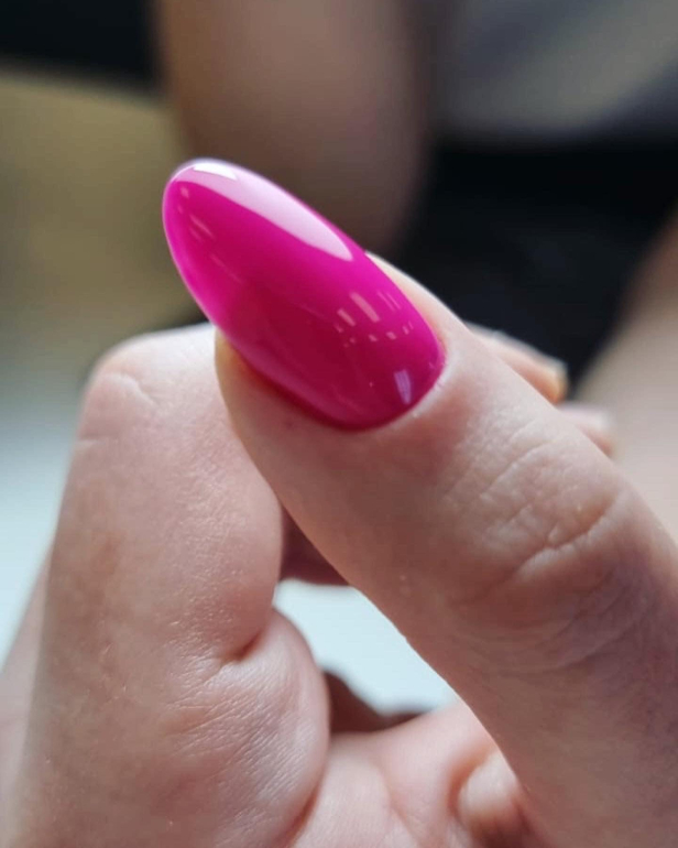 Almond-shaped fuchsia gel nails created using professional nail styling techniques.