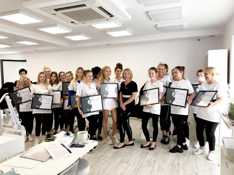 Certified Beauty Expert School graduates holding certificates after successfully completing the program and passing their exams.