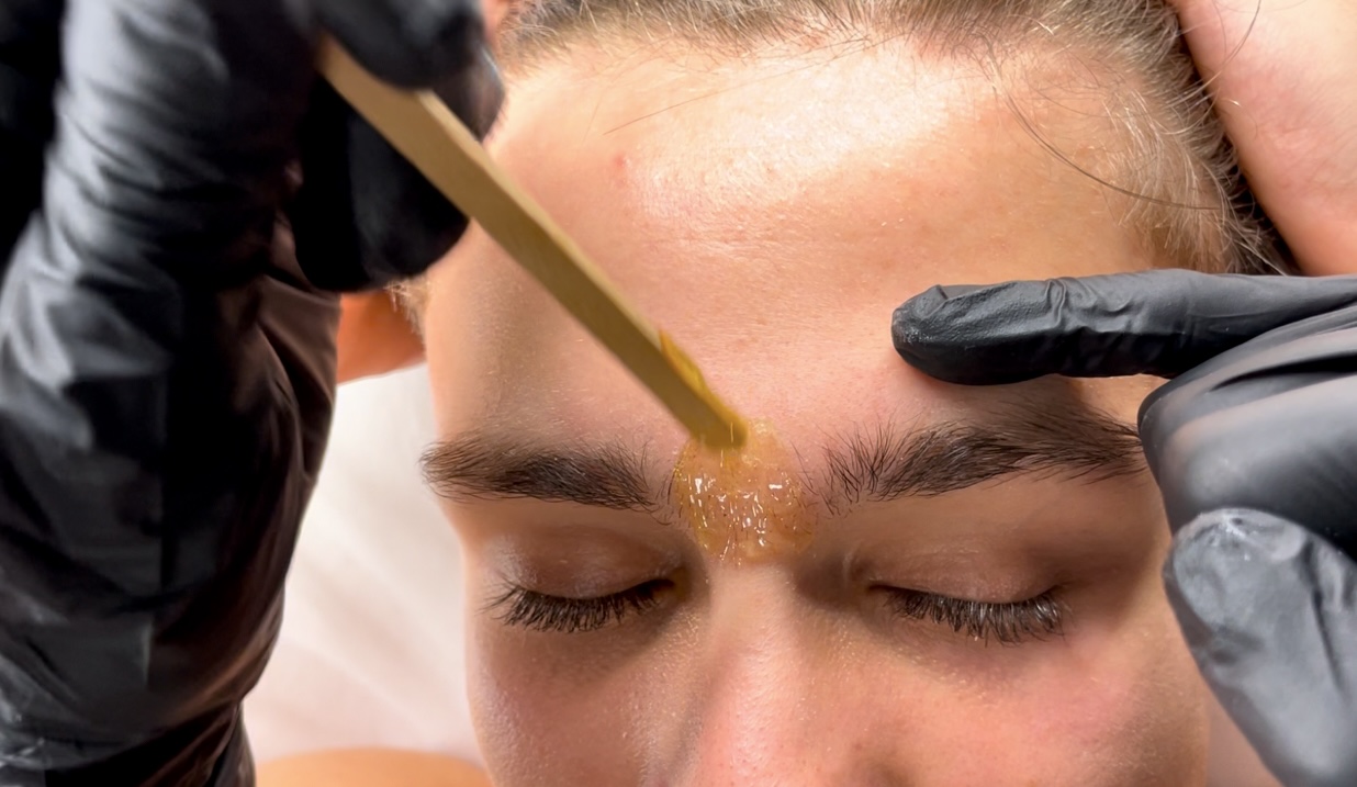 Practical waxing training – facial, body, and male waxing procedures performed with various types of wax during a professional beauty course.