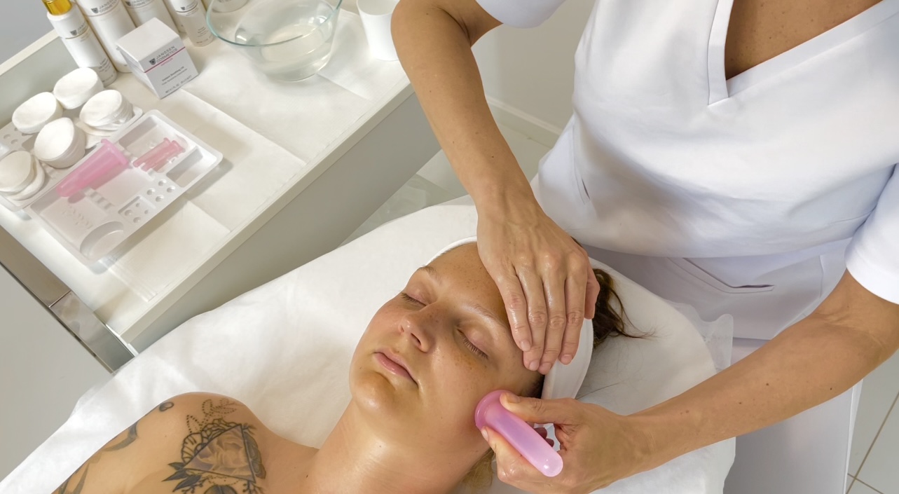 Lifting facial cupping massage – vacuum technique demonstrated during an online beauty school lesson.